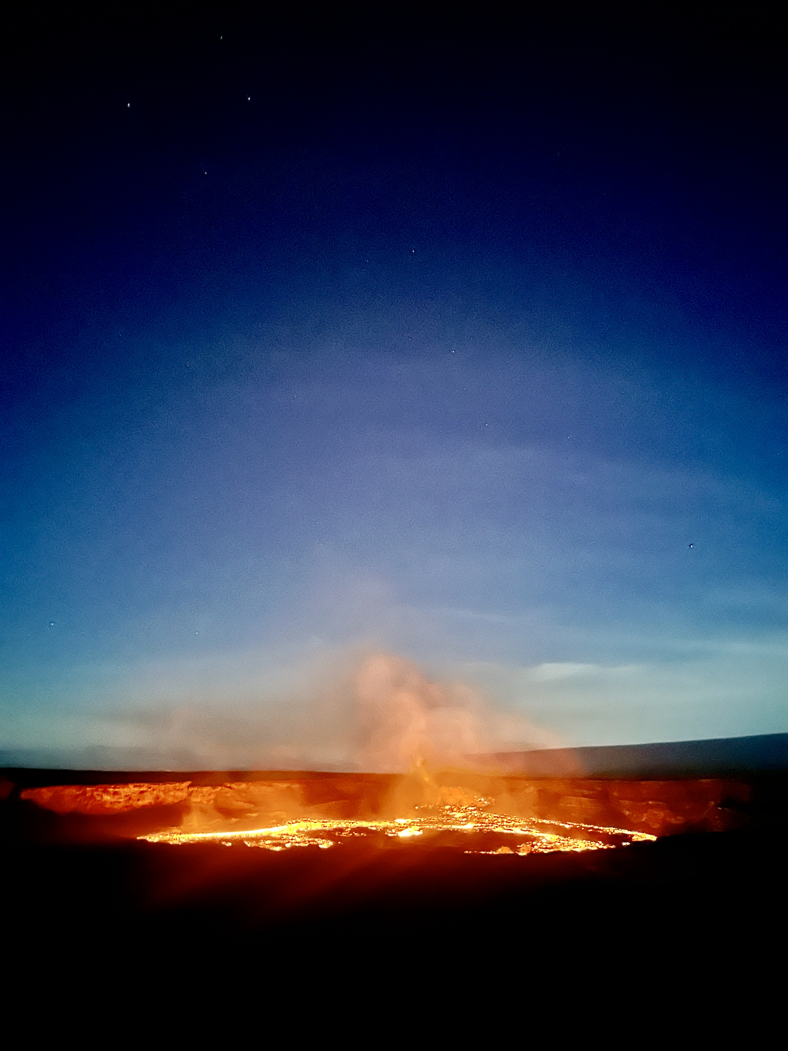 Kīlauea crater glowing at night with stars above, Hawaiʻi Volcanoes National Park